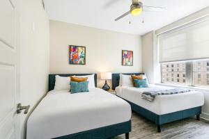 two beds in a room with a window at Spacious 4BR Luxury Condo Steps to French Quarter in New Orleans