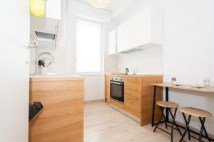 una cocina con paredes blancas y encimeras y taburetes de madera en MAMO'S BELVEDERE, en Faggeto Lario 