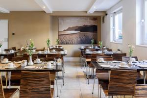 um restaurante com mesas e cadeiras e um quadro na parede em Kensington Court Hotel - Earls Court em Londres