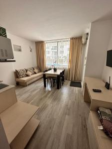 ein Wohnzimmer mit Sofa und Tisch in der Unterkunft AVALON, Apartment C102 in Sonnenstrand