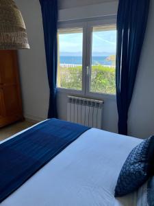 um quarto com uma cama e vista para o oceano em Villa La Palmera y El Mar em Naveces