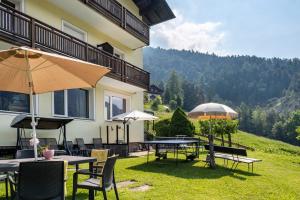 Un patio con mesas y sombrillas frente a un edificio. en Salman, en Ortisei