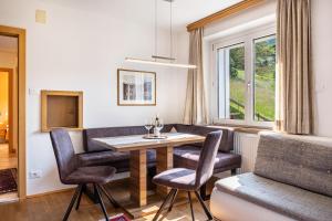 Un comedor con mesa y sillas y una ventana. en Salman, en Ortisei