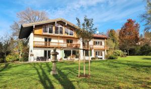ein großes Haus auf einem grünen Hof mit einem Baum in der Unterkunft Villa Marga Ferienwohnung Steinernes Meer in Schönau am Königssee