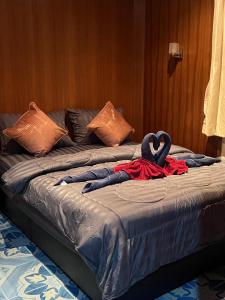 a bed with two towels on top of it at SK Hometel Samui Airport in Bangrak Beach