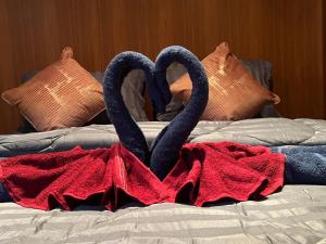 two swans forming a heart on a bed at SK Hometel Samui Airport in Bang Rak Beach