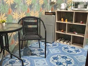 a chair and a table in a room with a refrigerator at SK Hometel Samui Airport in Bang Rak Beach