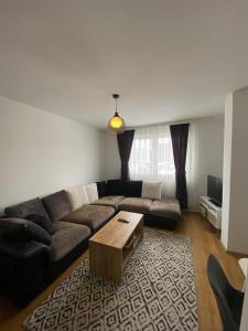 a living room with a couch and a coffee table at Cozy near City Center Apartment! in Pristina