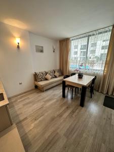 ein Wohnzimmer mit Tisch und Couch in der Unterkunft AVALON, Apartment C102 in Sonnenstrand