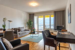 ein Wohnzimmer mit einem Sofa und einem Tisch in der Unterkunft Tertianum Residenza Hotel & Ristorante Al Parco in Locarno