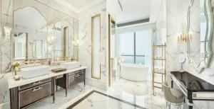 La salle de bains est pourvue de 2 lavabos, d'une baignoire et d'un grand miroir. dans l'établissement The St. Regis Zhuhai, à Zhuhai