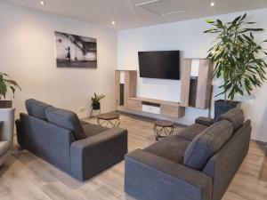 ein Wohnzimmer mit 2 Sofas und einem Flachbild-TV in der Unterkunft RingRooms in Knittelfeld