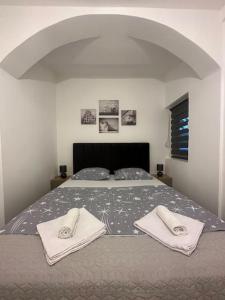 een slaapkamer met een bed met twee handdoeken erop bij Apartment Ninas in Dobrota