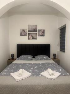 ein Schlafzimmer mit einem Bett mit zwei Handtüchern darauf in der Unterkunft Apartment Ninas in Dobrota