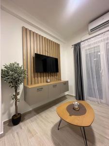 ein Wohnzimmer mit einem Flachbild-TV und einem Tisch in der Unterkunft Apartment Ninas in Dobrota