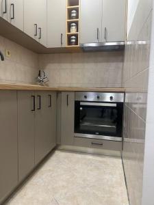 een keuken met witte kasten en een roestvrijstalen oven bij Apartment Ninas in Dobrota