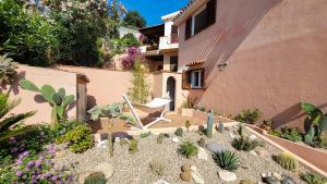 um jardim com cactos e uma cadeira em frente a uma casa em Il Giardino davanti al Mare em Orosei