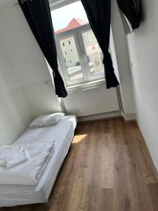 een kleine slaapkamer met een bed en een raam bij Gostilna in apartmaji Zlati lev - Maribor in Maribor
