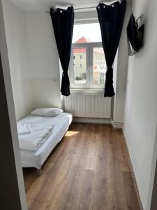 een kleine kamer met een bed en een raam bij Gostilna in apartmaji Zlati lev - Maribor in Maribor