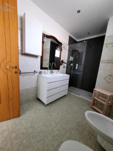 La salle de bains est pourvue d'un lavabo blanc et d'un miroir. dans l'établissement Kalimera, à Bari