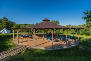 a gazebo with hammocks and a tent at Szellős Rét Camping in Bálványos