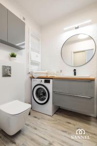 uma casa de banho com uma máquina de lavar roupa e um lavatório em Apartament River Side - Marina Dziwnów em Dziwnów