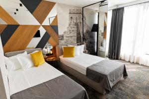 a hotel room with two beds with yellow pillows at MM Boutique Hotel in Burgas City