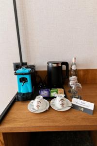 a wooden table with two cups and plates on it at MM Boutique Hotel in Burgas
