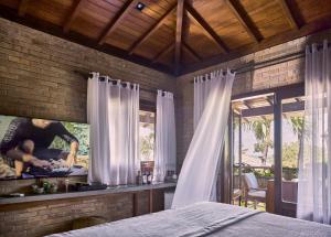 a bedroom with a bed and a kitchen with a window at Pousada Jeribá in Jericoacoara