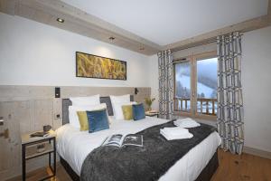Un dormitorio con una cama grande y una ventana en Les Chalets de Joy en Le Grand-Bornand