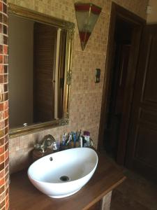 a bathroom with a white sink and a mirror at Diana Apartman in Balatonszepezd