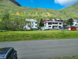 a parking lot with houses and a mountain in the background at The Painter's house in Siglufjörður