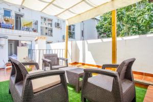 a patio with wicker chairs and tables on a balcony at apartamento con terraza in Valencia