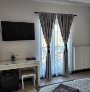 uma sala de estar com uma secretária e uma janela em My room accommodation em Curtea de Argeş