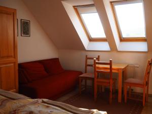 a attic room with a couch and a table and chairs at Privat Alenka in Liptovský Mikuláš