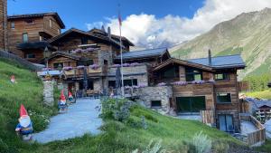 a log cabin in the mountains with people in front of it at Boutique Lodge Spycher in Saas-Fee
