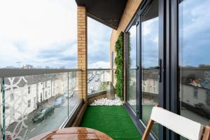 a balcony with green flooring and large windows at Your Apartment Awaits! in Gillingham