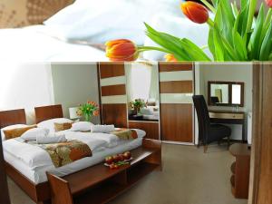a bedroom with two beds and a desk and flowers at An-Son Apartamenty in Zielona Góra