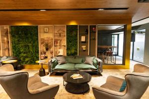 a living room with a green couch and chairs at MM Boutique Hotel in Burgas