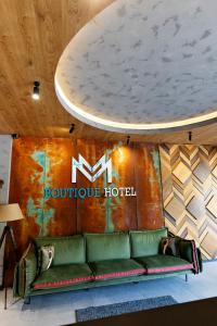 a couch in front of a booth at a hotel at MM Boutique Hotel in Burgas