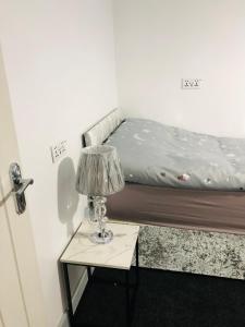 a bedroom with a bed and a table with a lamp at Modern Travis House in Burnley