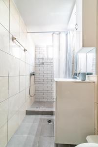 a white bathroom with a shower and a toilet at BeachFront Apt next to the Mall in Heraklio