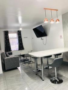 een eetkamer met een witte tafel en stoelen bij Modern Travis House in Burnley