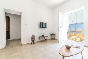 a living room with a table and a view of the ocean at BeachFront Apt next to the Mall in Heraklio