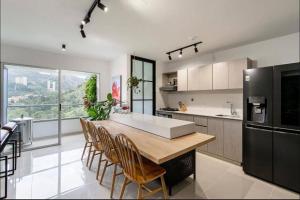 a kitchen with a table and chairs and a large window at Apartamento amoblado en Sabaneta in Sabaneta