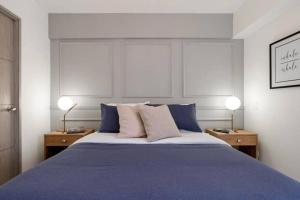 a bedroom with a large bed with blue sheets and two lamps at Apartamento amoblado en Sabaneta in Sabaneta