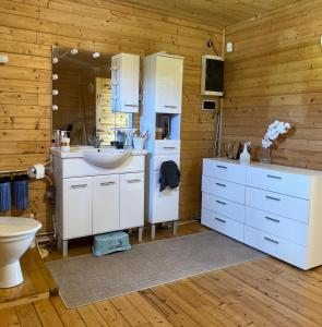 uma casa de banho com armários brancos, um lavatório e um WC. em Robadeli Holiday House em Remniku