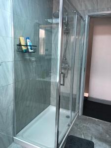 a shower with a glass door and a shower at Modern Travis House in Burnley