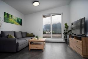 een woonkamer met een bank, een tv en een tafel bij Haus Nordketten Blick in Schönberg im Stubaital