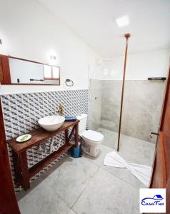 a bathroom with a sink and a toilet and a shower at Casa Tua Pipa in Pipa